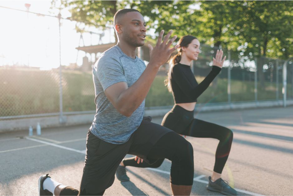 young couple doing lunges outside