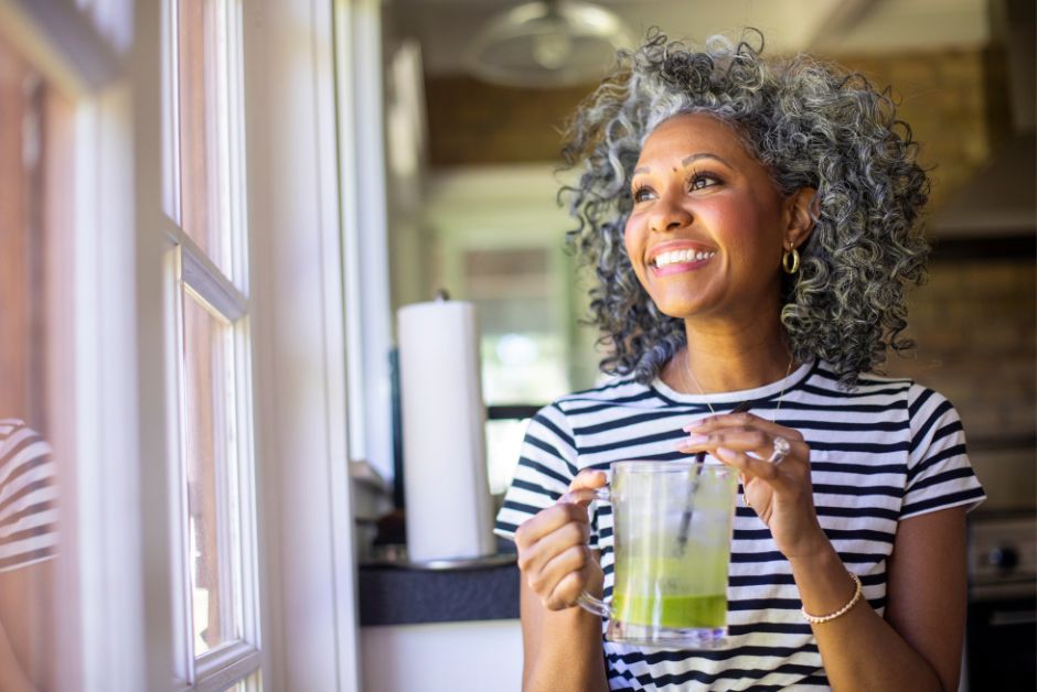 Middle aged woman smiling with a smoothie